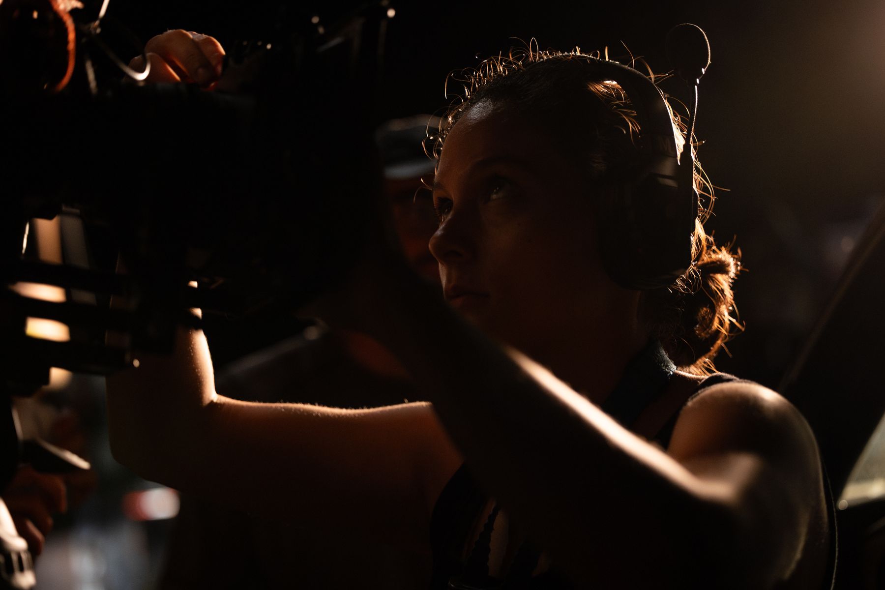 Actor lit in profile, framed past the camera rig during a take