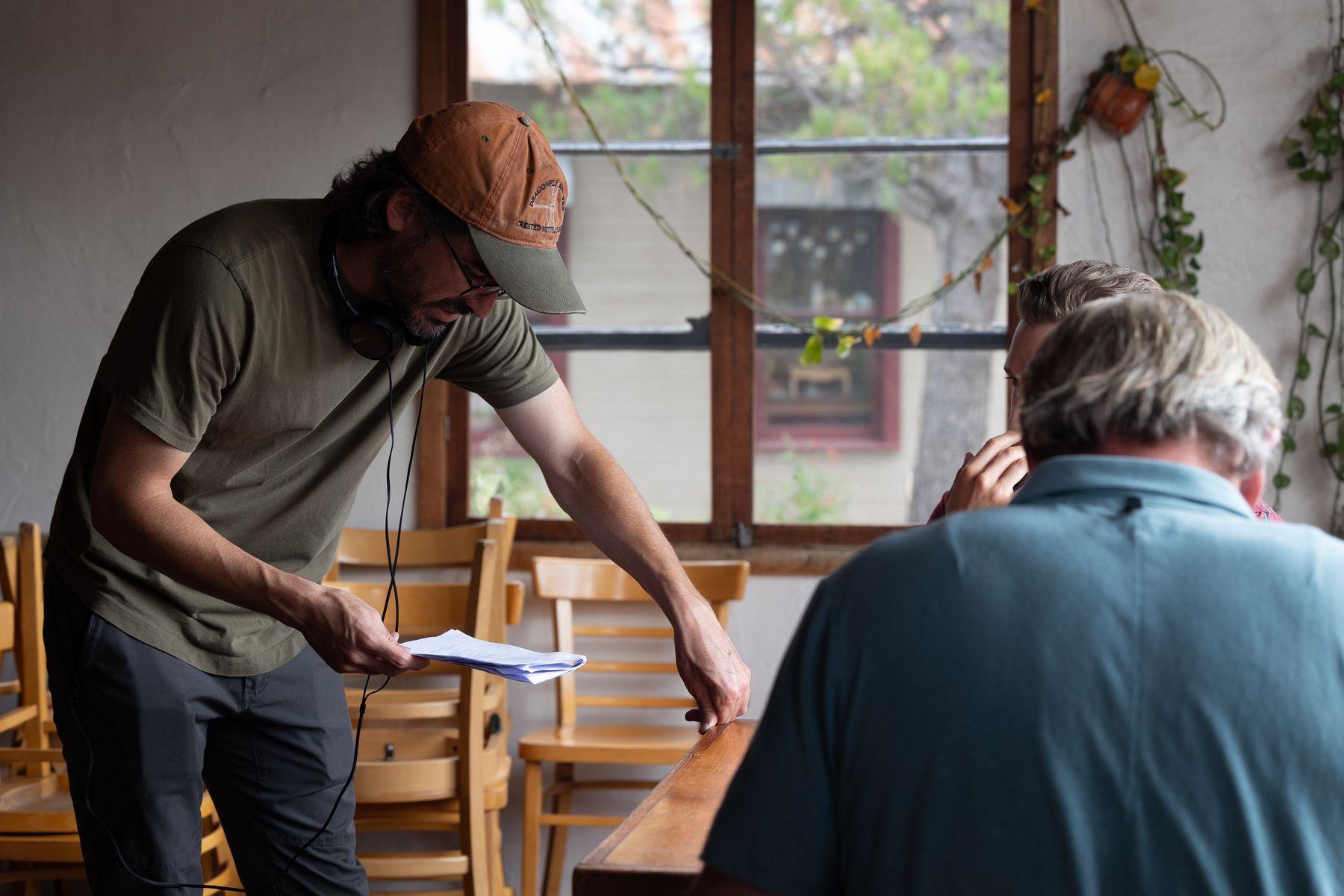 Director going over notes with an actor beside a stack of chairs